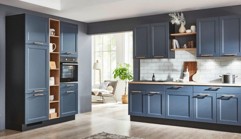 Modern fitted kitchen with dark blue cabinetry, integrated oven, open shelving and white tiled splashback