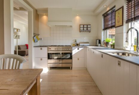 Bright fitted kitchen with light cabinetry, dark worktops, range cooker and large windows