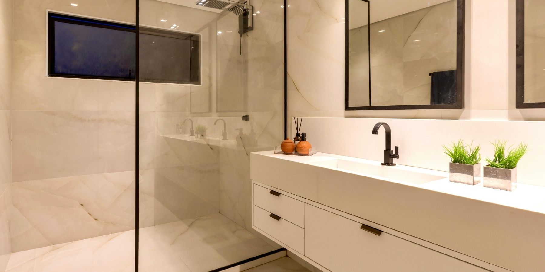 Alternative Text: Luxury bathroom with walk-in glass shower, floating vanity, large mirrors and black fittings