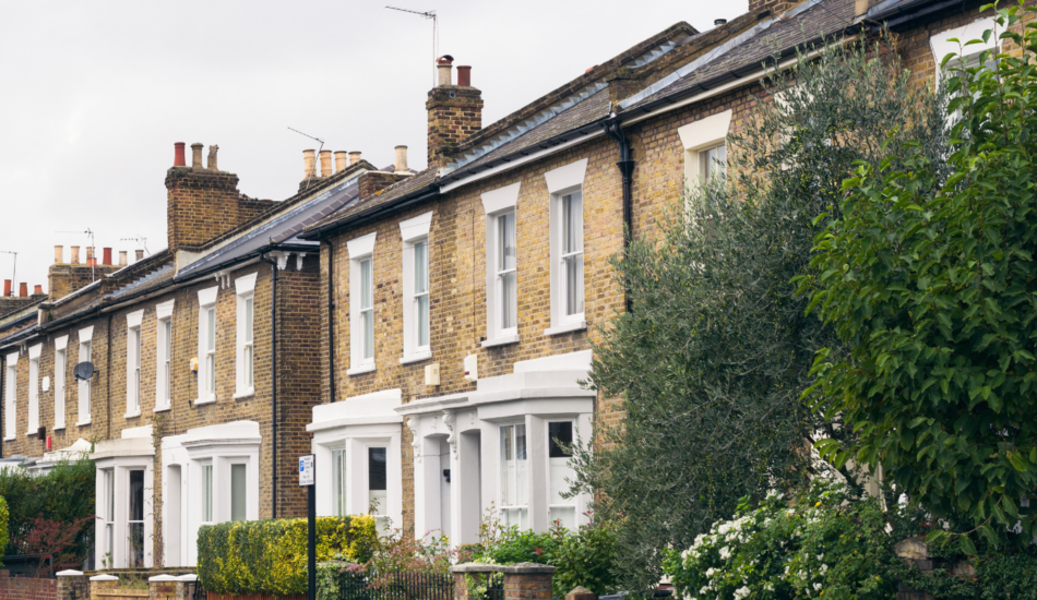 Row of traditional brick terraced houses with bay windows and front gardens in West Ealing, London