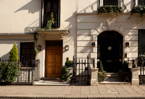 Elegant period townhouse entrances with traditional doors, iron railings and planted front gardens