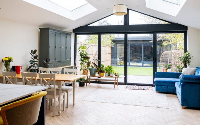 Bright open-plan living and dining space with skylights, glazed rear doors and garden access
