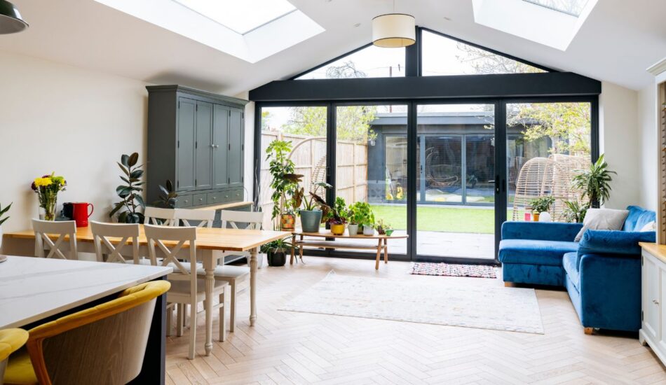 Bright open-plan living and dining space with skylights, glazed rear doors and garden access