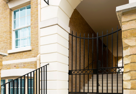 Traditional brick residential property with white stone detailing and black metal gates in Richmond, London