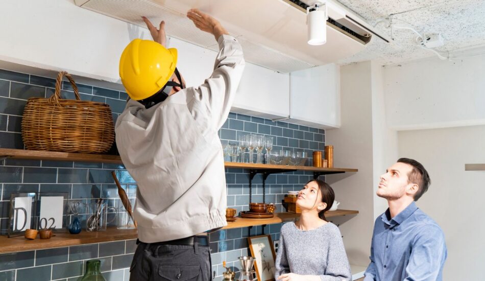 Property maintenance professional inspecting a ceiling while speaking with residents