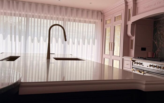 Luxury kitchen with large island, integrated sink, fitted cabinetry and range cooker