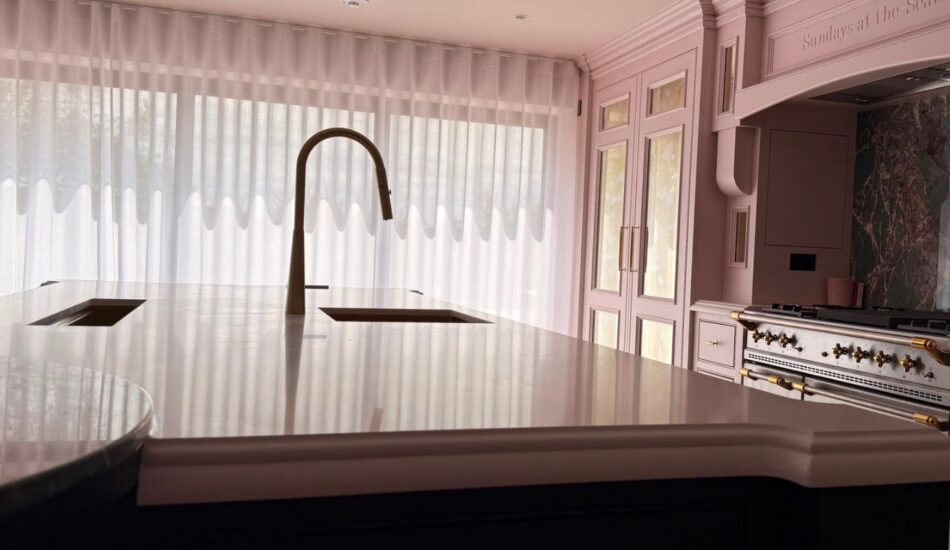 Luxury kitchen with large island, integrated sink, fitted cabinetry and range cooker