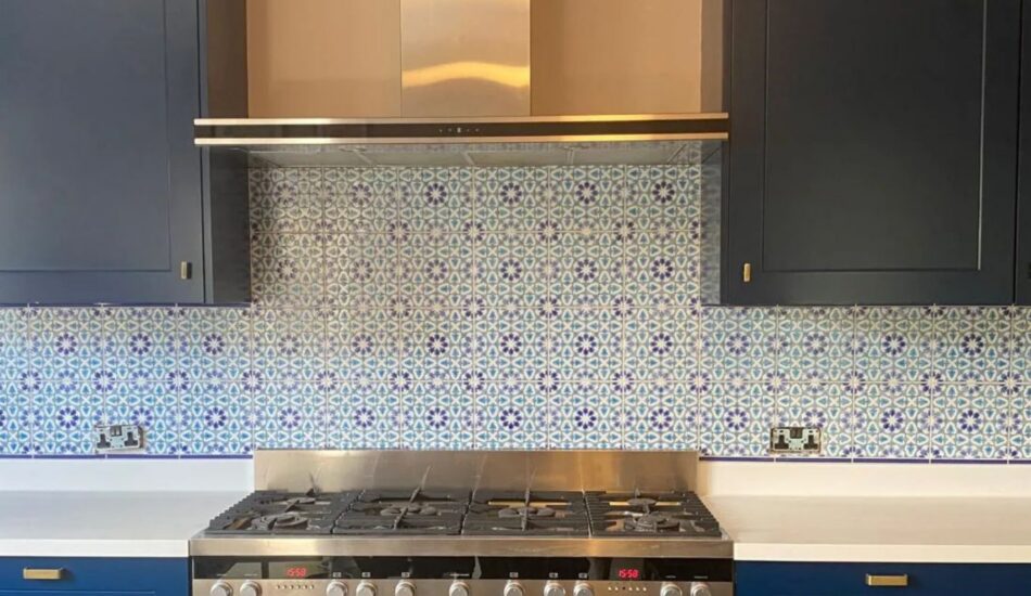 Patterned tile splashback installed behind a kitchen hob and worktop
