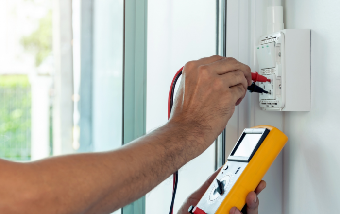 Electrician testing an electrical connection with a digital multimeter