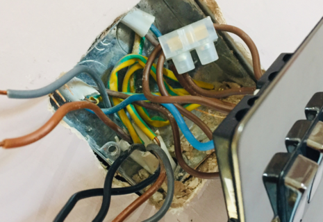 Exposed electrical wiring behind a multi-gang wall switch during installation