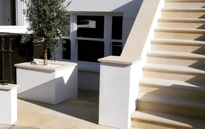 Renovated exterior stone steps with white rendered walls and paved entrance area