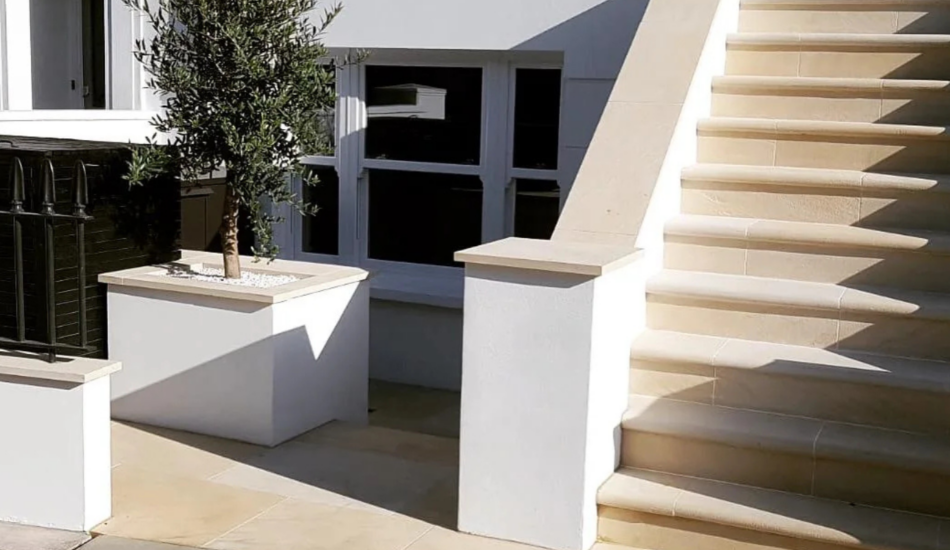 Renovated exterior stone steps with white rendered walls and paved entrance area